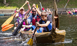 A groupd of people paddling in a large canoe